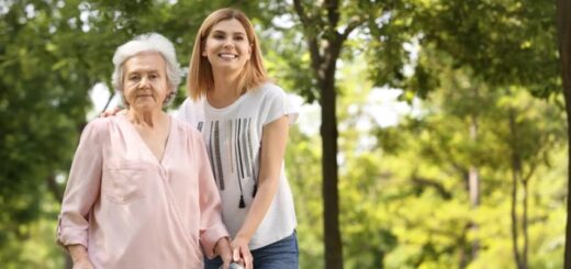 Photo d'une personne âgée avec un déambulateur et une jeune femme à sa droite.