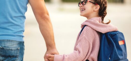 Photo d'une fille et son père, main dans la main.